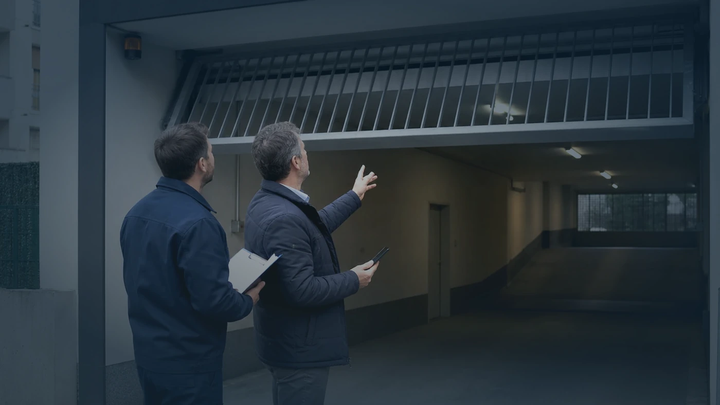 Tiefgaragenzufahrt bei Nacht mit geöffnetem Garagentor und Servicetechniker im Vordergrund in Wien Niederösterreich, realistische Technikfotografie ohne Logos